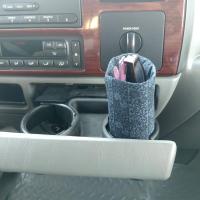 Dark blue upright weighted eyeglasses holder used as a car accessory in a vehicle cup holder.